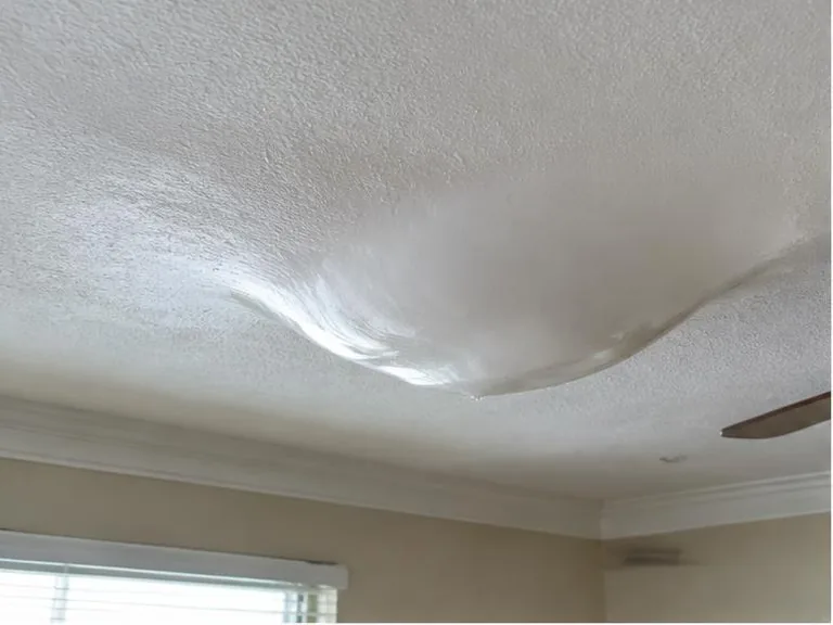 Sagging white ceiling with a large water-filled bulge.